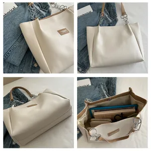 Detail view of large cream tote bag showing spacious interior for tablets and books