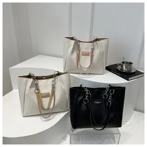 Detailed view of large tote bags with metal chains and leather fashion labels