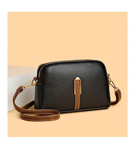 Detail view of the black lychee pattern leather crossbody bag with dual zipper compartments