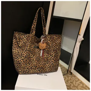 Details einer Canvas-Einkaufstasche mit Leopardenmuster und braunem Bärenanhänger