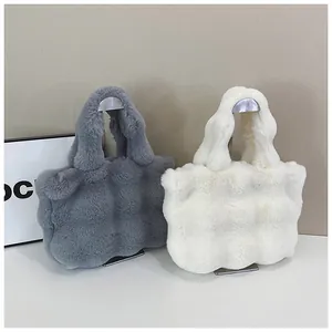 Gros plan de sacs cabas en peluche gris et blanc avec texture sur support métallique
