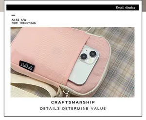 Detail der pinkfarbenen Handy-Umhängetasche mit Fronttasche, Smartphone und Gurt