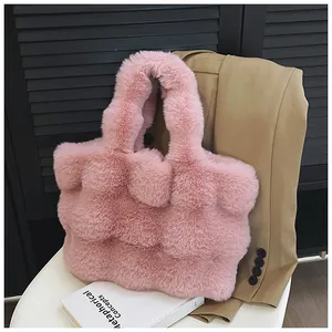Gros plan du sac cabas rose en peluche sur une chaise montrant la texture en fausse fourrure