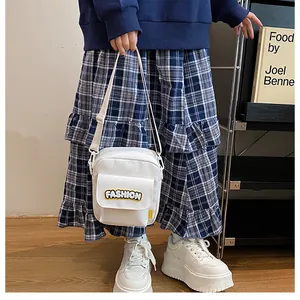 Detail of white canvas crossbody phone bag with yellow FASHION lettering on model