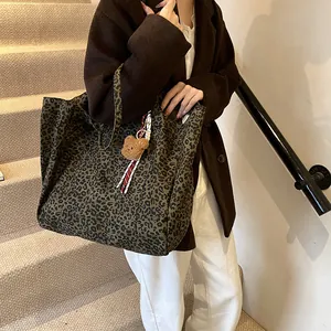 Große Canvas-Tragetasche mit Leopardenmuster und Bärenanhänger am Model getragen