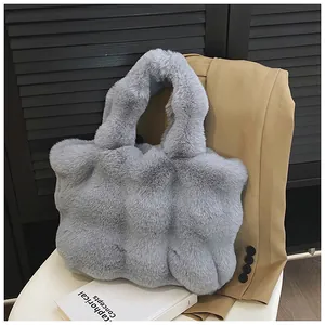 Détail du cabas en fausse fourrure bleu clair avec motif matelassé sur chaise
