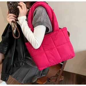 Dettaglio della borsa tote trapuntata fucsia che mostra capienza e consistenza soffice
