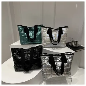 Gros plan de sacs cabas matelassés en bleu, blanc, noir et finitions métalliques