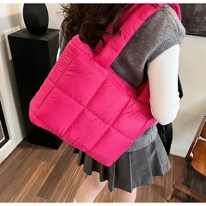 Vista laterale di una borsa tote imbottita rosa acceso indossata da una modella in interno