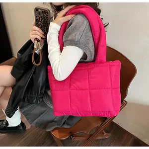 Dettaglio della borsa shopper trapuntata rosa brillante con trama imbottita e tessuto lucido