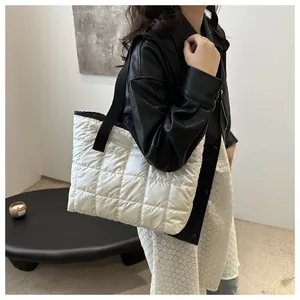 Détail du sac fourre-tout matelassé blanc avec finition brillante et bandoulière