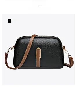 Front view of black pebbled leather crossbody bag with brown trim and gold hardware