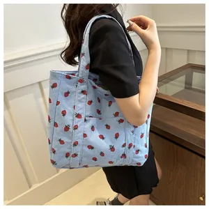 Detail van lichtblauwe corduroy tote bag met aardbeienprint en handig zijvakje