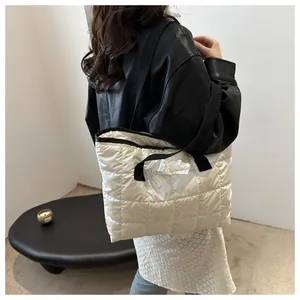 Détail du grand sac cabas matelassé blanc avec des sangles en nylon noir contrastées