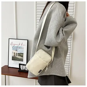 Minimalistische beige Nylon-Handytasche mit SPORT-Label in einer Lifestyle-Szenerie