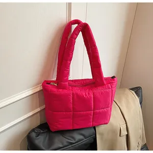 Dettaglio della borsa tote trapuntata fucsia con cerniera e manici imbottiti