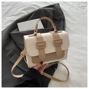 Detailed macro view of the two-tone PU leather crossbody bag with buckle straps