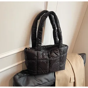 Dettaglio della borsa tote trapuntata nera con manici imbottiti e cerniera dorata