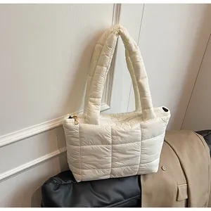 Dettaglio della borsa tote trapuntata bianca con manici larghi e cerniera in metallo dorato