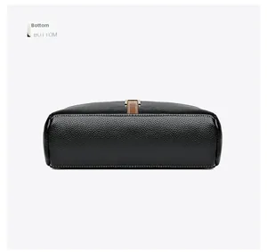 Detail of black pebbled leather bag bottom with contrast white stitching and gold hardware