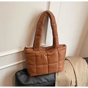 Dettaglio della borsa shopper trapuntata marrone in nylon con texture puffy e zip metallica