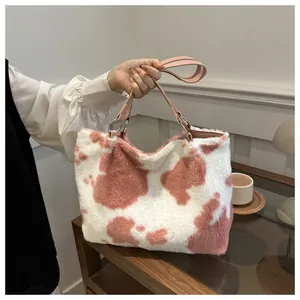 Detailansicht der flauschigen rosa Kuhmuster-Tasche mit Kunstledergriffen und Ringen