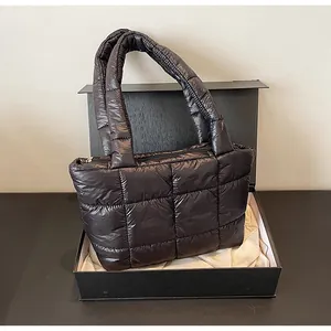 Dettaglio di borsa tote trapuntata nera in una confezione regalo con fodera in raso