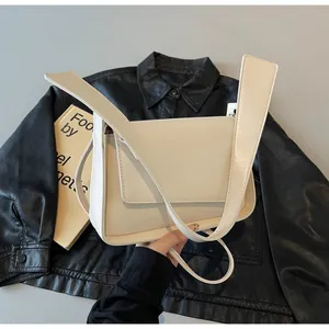 Detailopname van beige rechthoekige crossbodytas met gladde textuur en dubbele schouderbanden