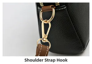Detail of shoulder strap hook with gold hardware and contrast stitching on black leather