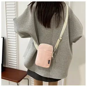 Detailansicht der rosa Nylon-Handytasche mit SPORT-Label und breitem Gurtband