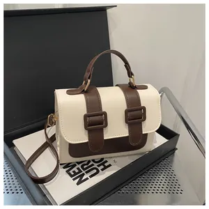 Detail view of contrast color crossbody bag with retro buckles in a gift box