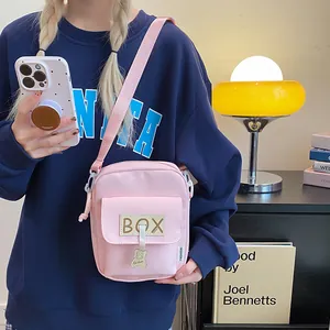 Cute pink canvas crossbody phone bag for women with adjustable strap and bear pendant