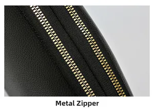 Close-up of premium gold metal zipper on black textured leather shoulder bag