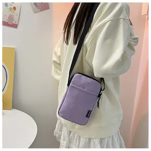 Detailansicht der lila Nylon-Umhängetasche mit verstellbarem Gurt und Sport-Etikett