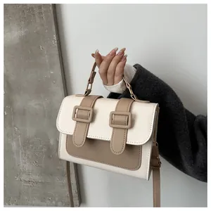 Detail of contrast color crossbody bag with buckle flap and textured PU leather