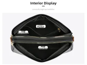 Detail view of black shell bag showing two main compartments and a zipper pocket