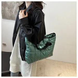 Vue détaillée du grand sac cabas matelassé vert métallisé porté à l'épaule pour femme