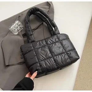 Dettaglio borsa tote nera trapuntata con manici imbottiti e finitura in nylon lucido
