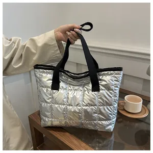 Détail du sac cabas matelassé argenté avec finition métallique et poignées noires