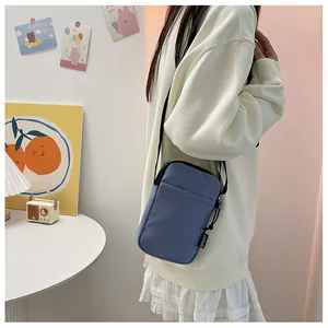 Detailansicht der blauen Nylon-Umhängetasche mit schwarzem SPORT-Webetikett