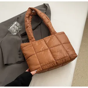 Dettaglio della borsa tote trapuntata marrone con ampi manici e chiusura a cerniera
