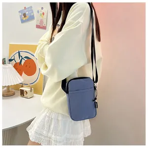 Details der hellblauen Nylon-Handytasche mit Gurt und Sport-Reißverschluss-Anhänger