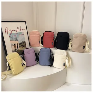 Mehrfarbige Mini-Schultertaschen aus Segeltuch auf einem weißen Displayständer
