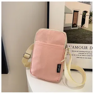 Detail der rosa Cord-Handytasche mit weicher Textur und Sport-Logo-Aufnäher