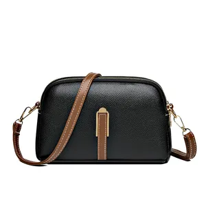 Minimalist black pebble leather half-moon crossbody bag with brown straps and gold hardware