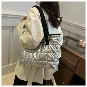 Détail du sac cabas matelassé argenté montrant la texture métallique et la bandoulière