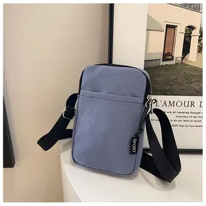 Nahaufnahme der hellblauen Cord-Handytasche mit Reißverschluss und Sport-Anhänger