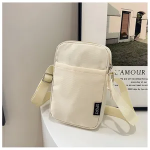Detailansicht der cremeweißen Cord-Handytasche mit Reißverschluss und Sport-Schultergurt