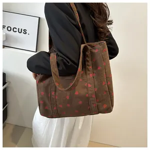 Detail van bruine corduroy shopper met een levendige rode aardbeienprint textuur