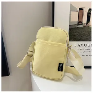 Details der gelben Nylon-Handytasche mit Sport-Label und verstellbarem Gurt